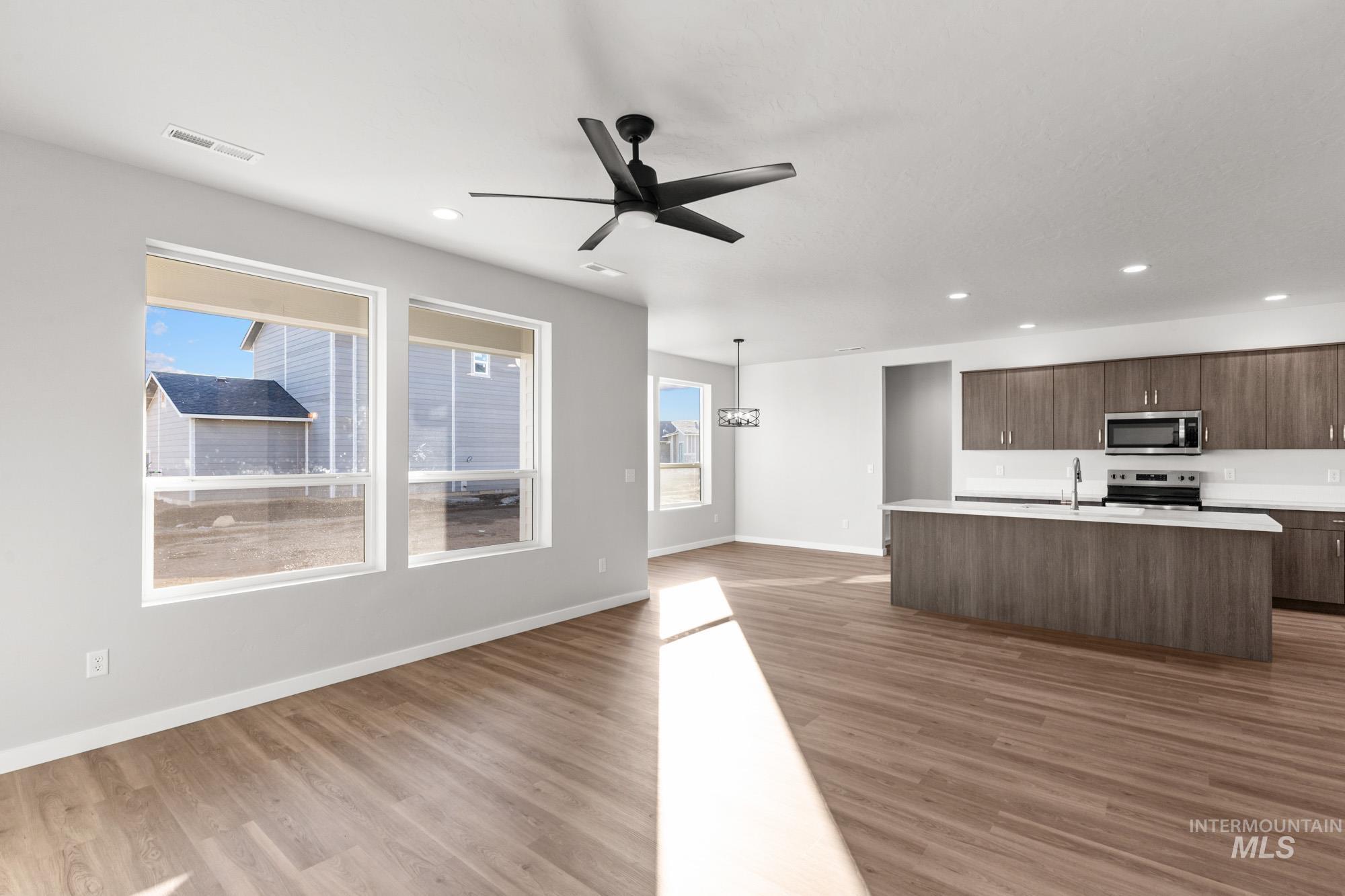 13713 Judson Street Caldwell, ID 83607 - Photo 24 of 24 Kitchen featuring open floor plan, ceiling fan, light wood-style floors, and hanging light fixtures