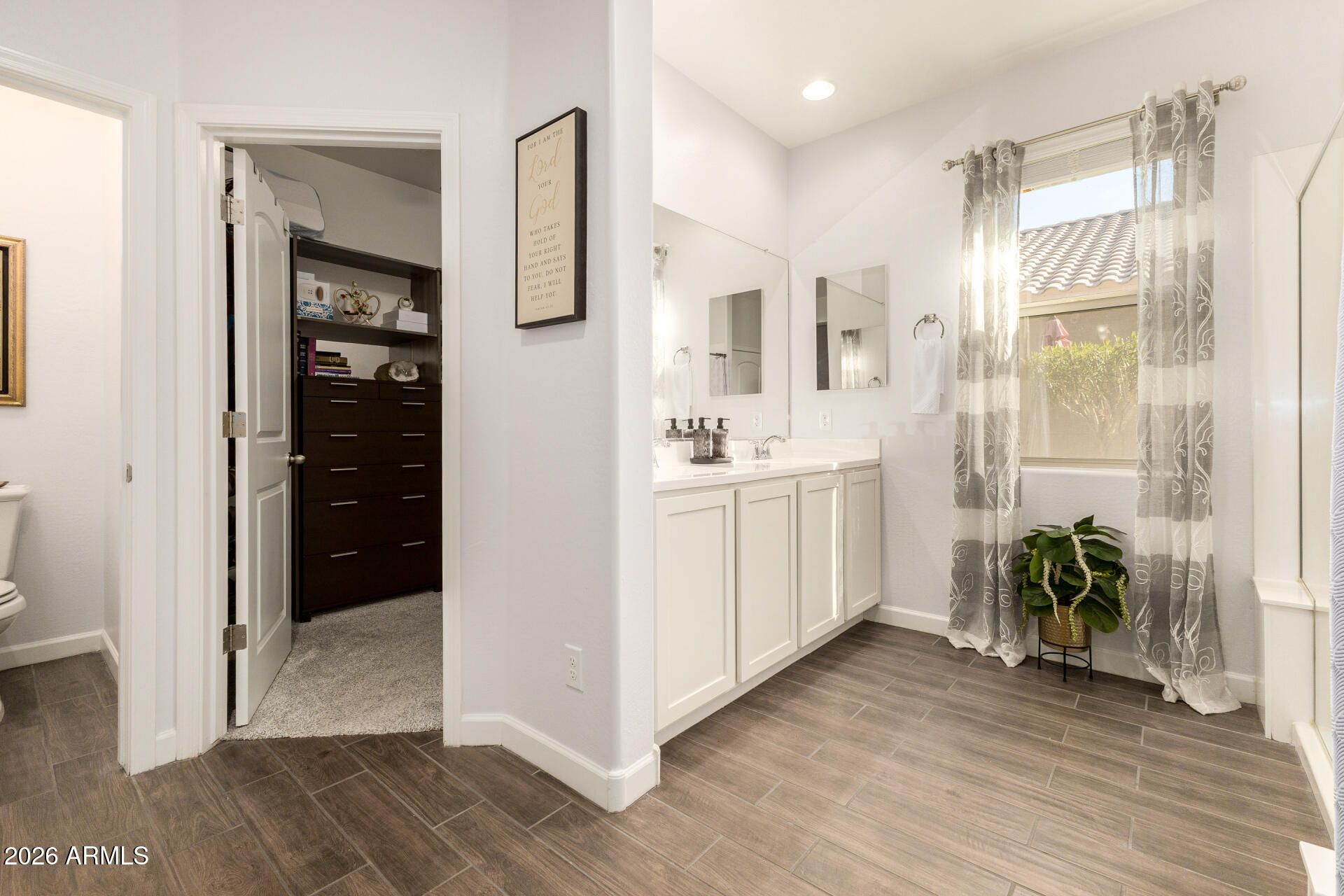 41039 West Williams Way Maricopa, AZ 85138 - Photo 11 of 25 a view of a hallway with wooden floor and a bathroom