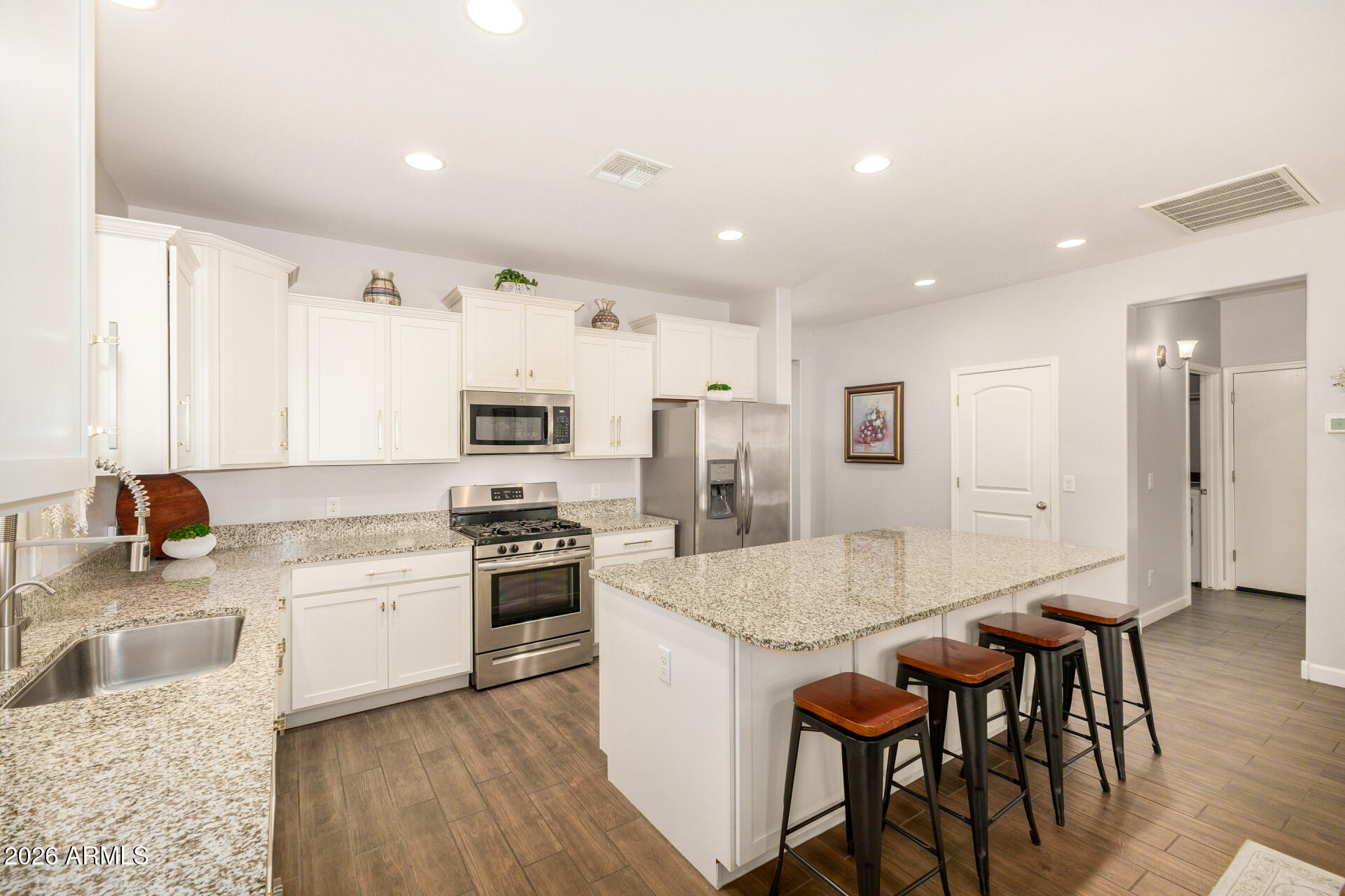 41039 West Williams Way Maricopa, AZ 85138 - Photo 7 of 25 a kitchen with stainless steel appliances granite countertop a stove top oven a sink refrigerator and cabinets