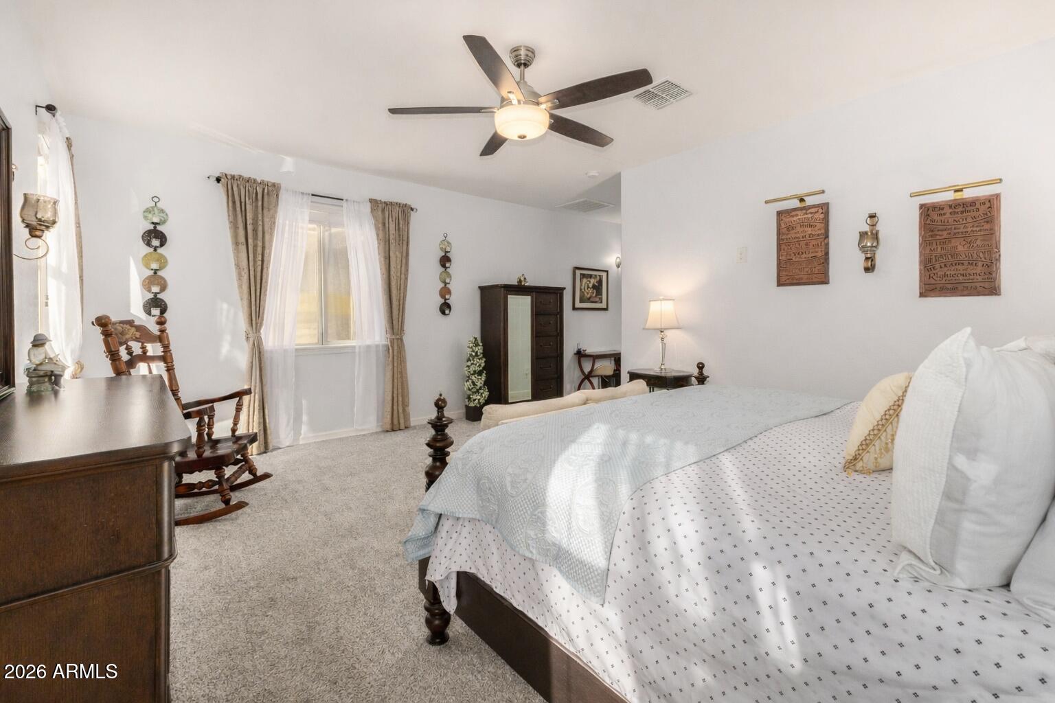 41039 West Williams Way Maricopa, AZ 85138 - Photo 10 of 25 a bed room with a bed and a chandelier