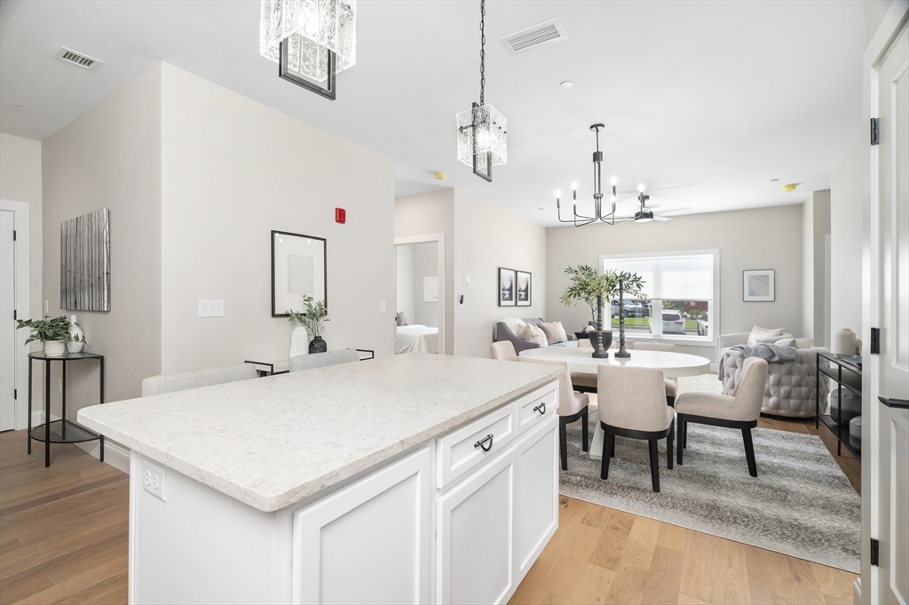 36 Old Louisquisset Pike, Unit 106 North Smithfield, RI 02896 - Photo 11 of 30 a large white kitchen with a table and chairs