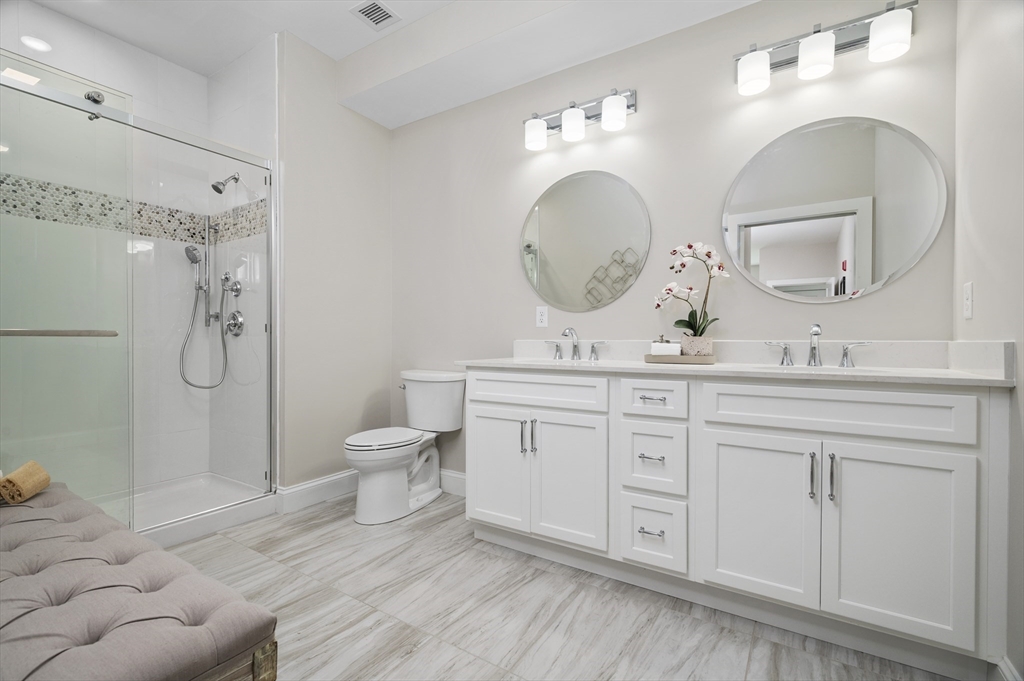 36 Old Louisquisset Pike, Unit 106 North Smithfield, RI 02896 - Photo 19 of 30 a bathroom with a double vanity sink toilet and a mirror