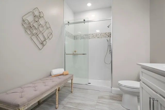 a bathroom with a granite countertop sink a toilet and shower