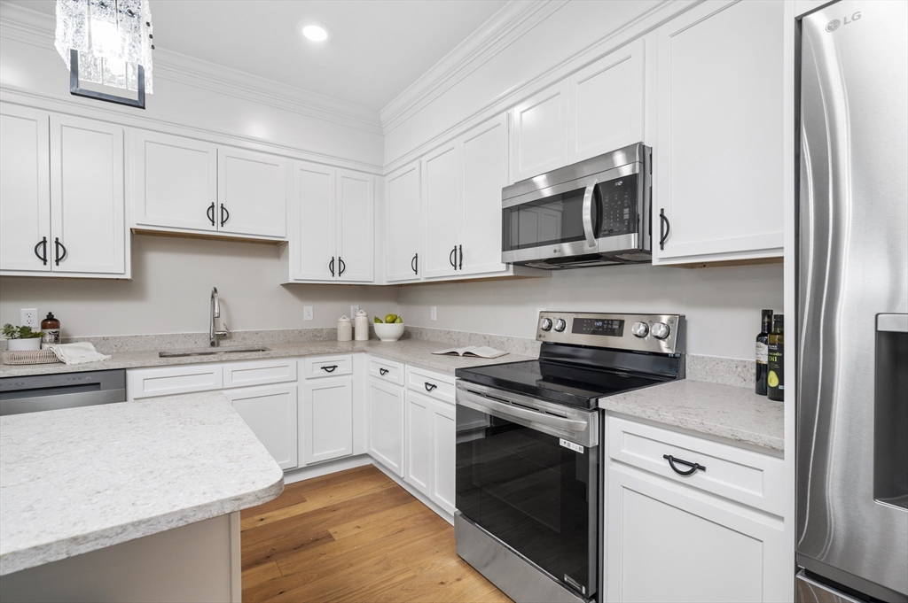 36 Old Louisquisset Pike, Unit 106 North Smithfield, RI 02896 - Photo 5 of 30 a kitchen with cabinets stainless steel appliances and a sink