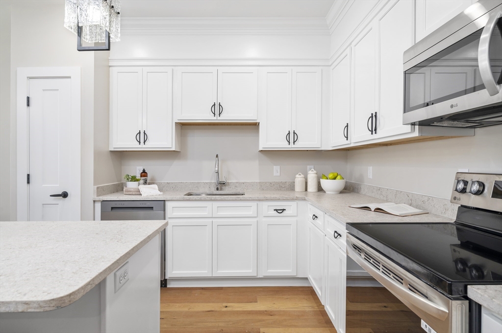 36 Old Louisquisset Pike, Unit 106 North Smithfield, RI 02896 - Photo 10 of 30 a kitchen with a sink stove and cabinets