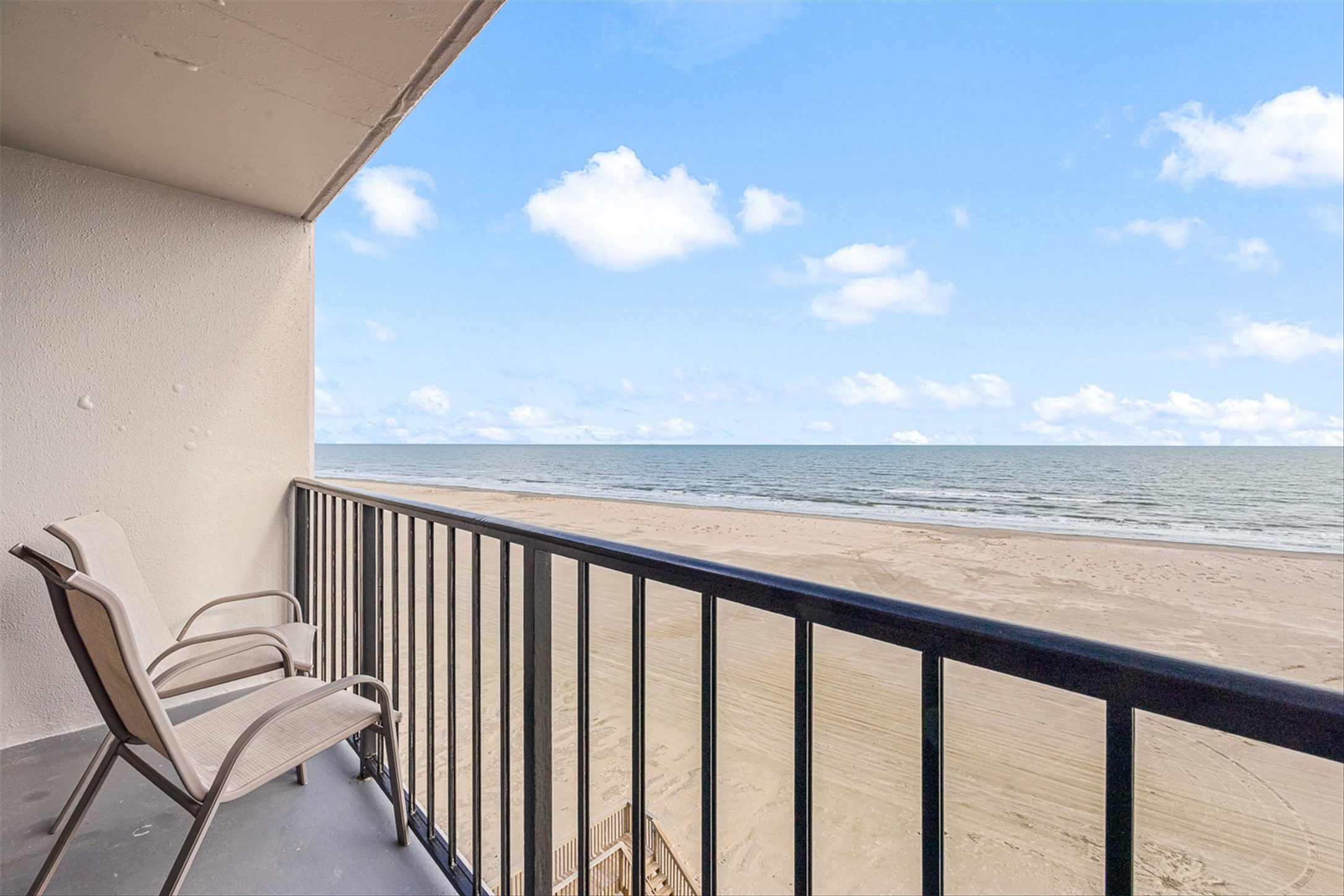 Balcony featuring view of water and beach