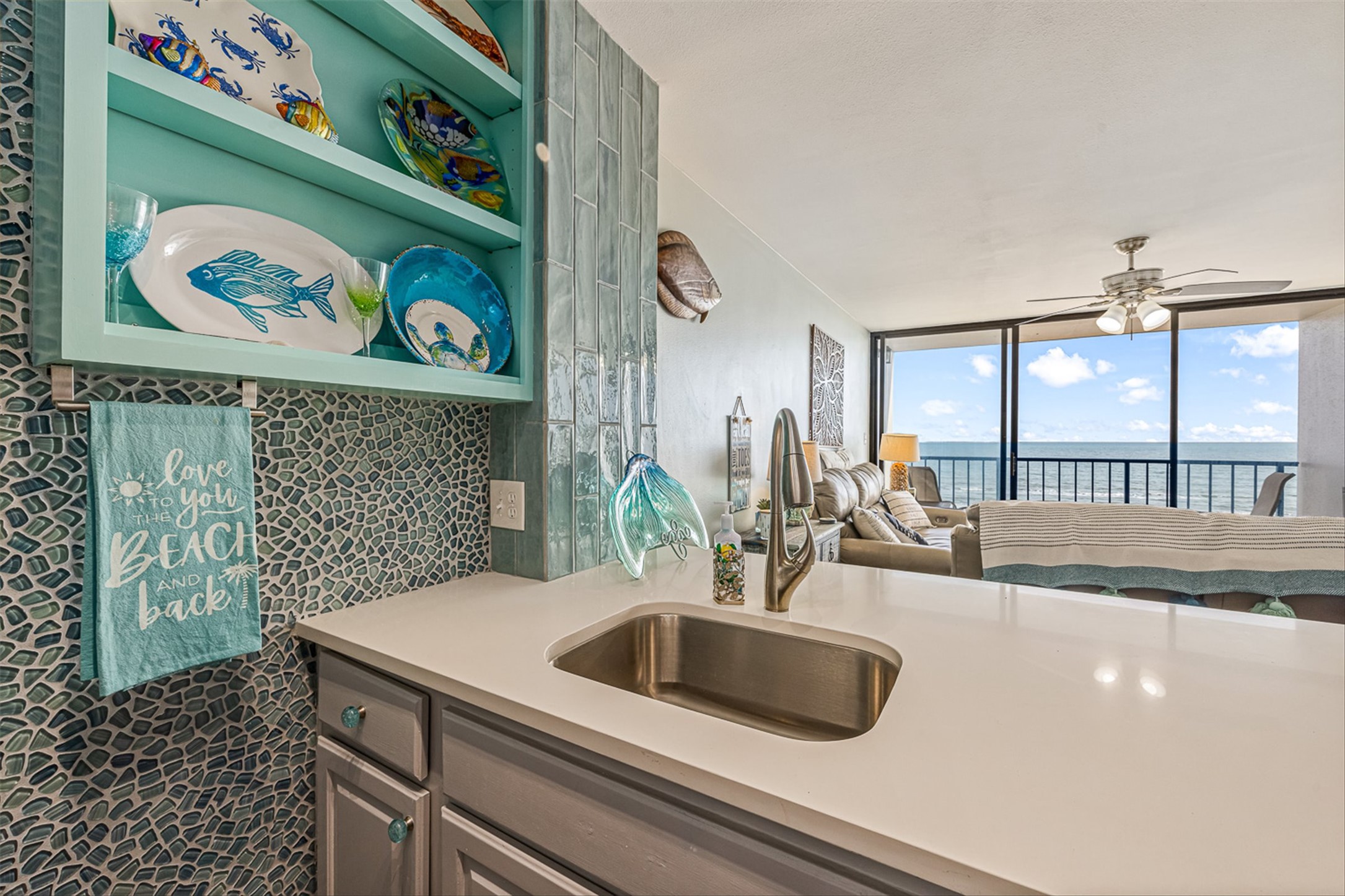 11945 Termini-San Luis Pass Road, Unit 406 Galveston, TX 77554 - Photo 24 of 26 Kitchen featuring open shelves, gray cabinets, a ceiling fan, open floor plan, and a water view