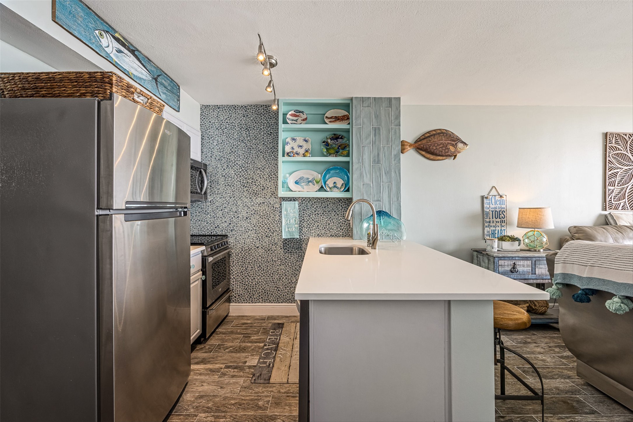 11945 Termini-San Luis Pass Road, Unit 406 Galveston, TX 77554 - Photo 25 of 26 Kitchen with stainless steel appliances, open shelves, open floor plan, a kitchen bar, and light stone counters