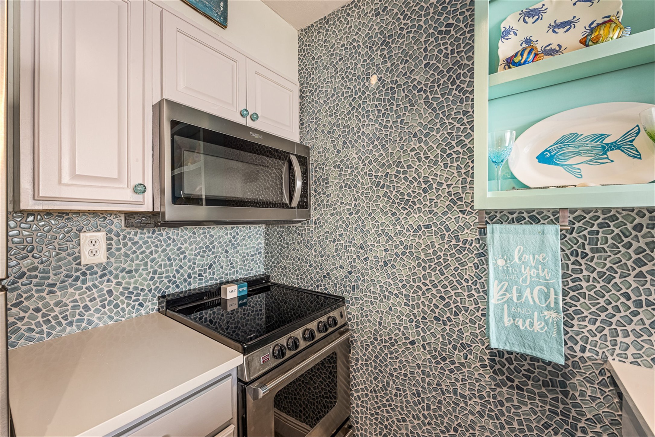 11945 Termini-San Luis Pass Road, Unit 406 Galveston, TX 77554 - Photo 14 of 26 Kitchen featuring stainless steel appliances, light countertops, and white cabinetry