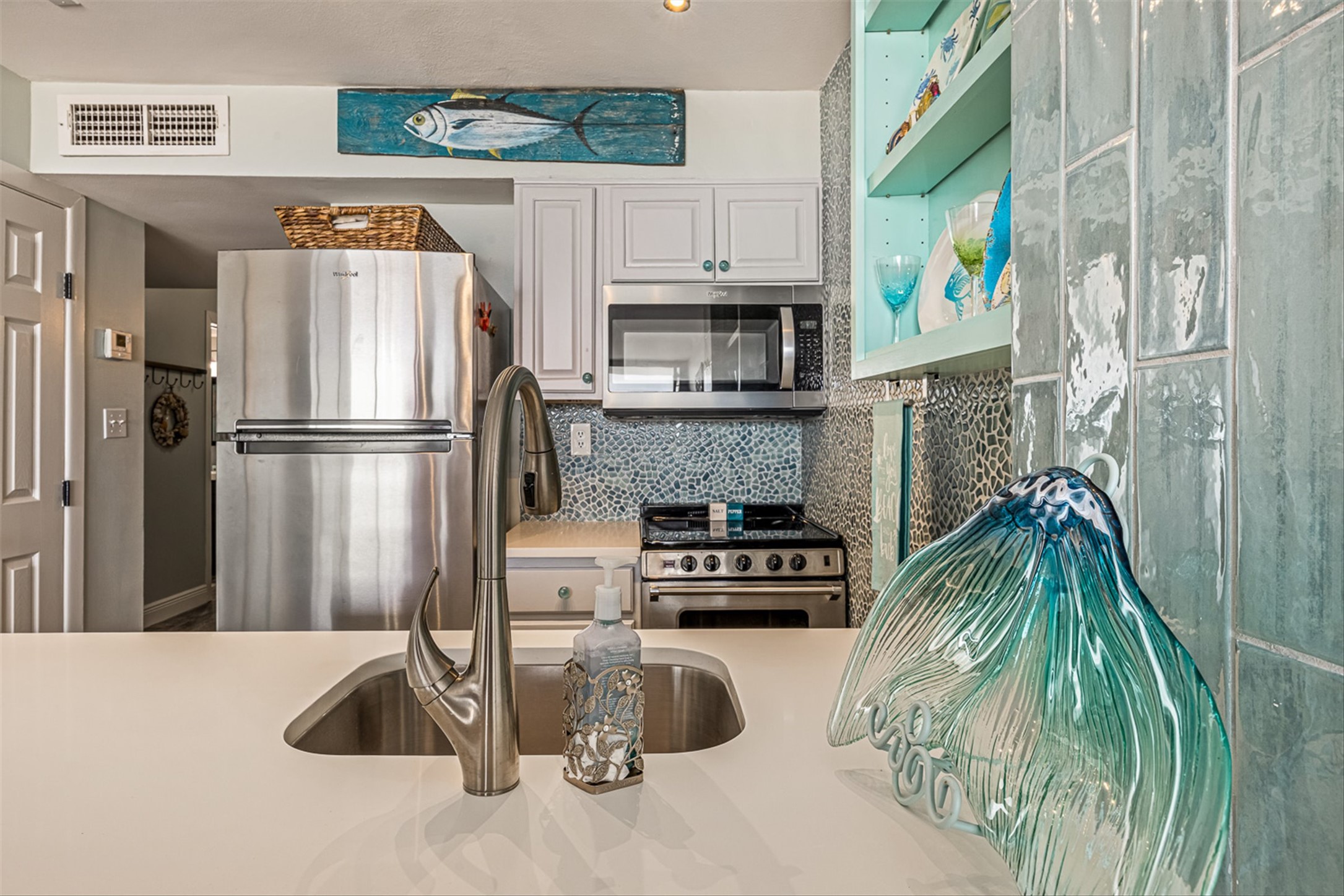 11945 Termini-San Luis Pass Road, Unit 406 Galveston, TX 77554 - Photo 15 of 26 Kitchen with stainless steel appliances, white cabinetry, and tasteful backsplash