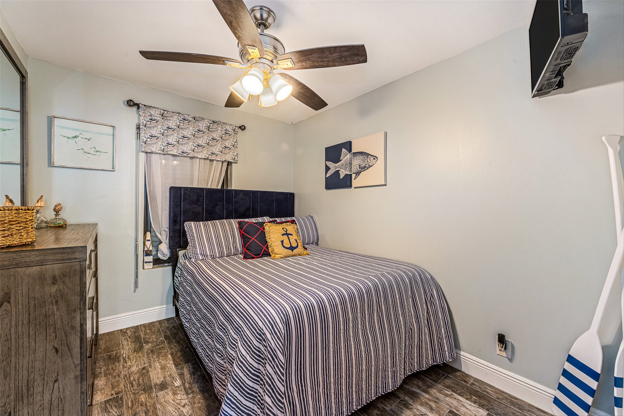 11945 Termini-San Luis Pass Road, Unit 406 Galveston, TX 77554 - Photo 19 of 26 Bedroom with dark wood finished floors and ceiling fan