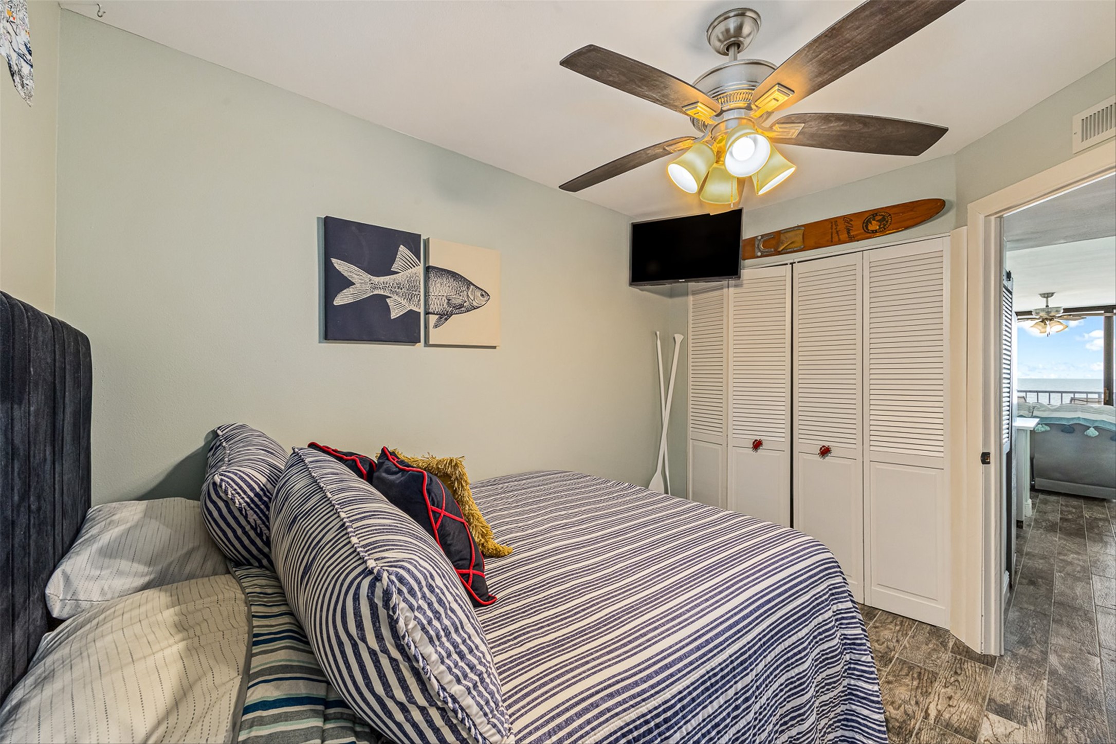 11945 Termini-San Luis Pass Road, Unit 406 Galveston, TX 77554 - Photo 20 of 26 Bedroom with wood finished floors, a closet, and a ceiling fan