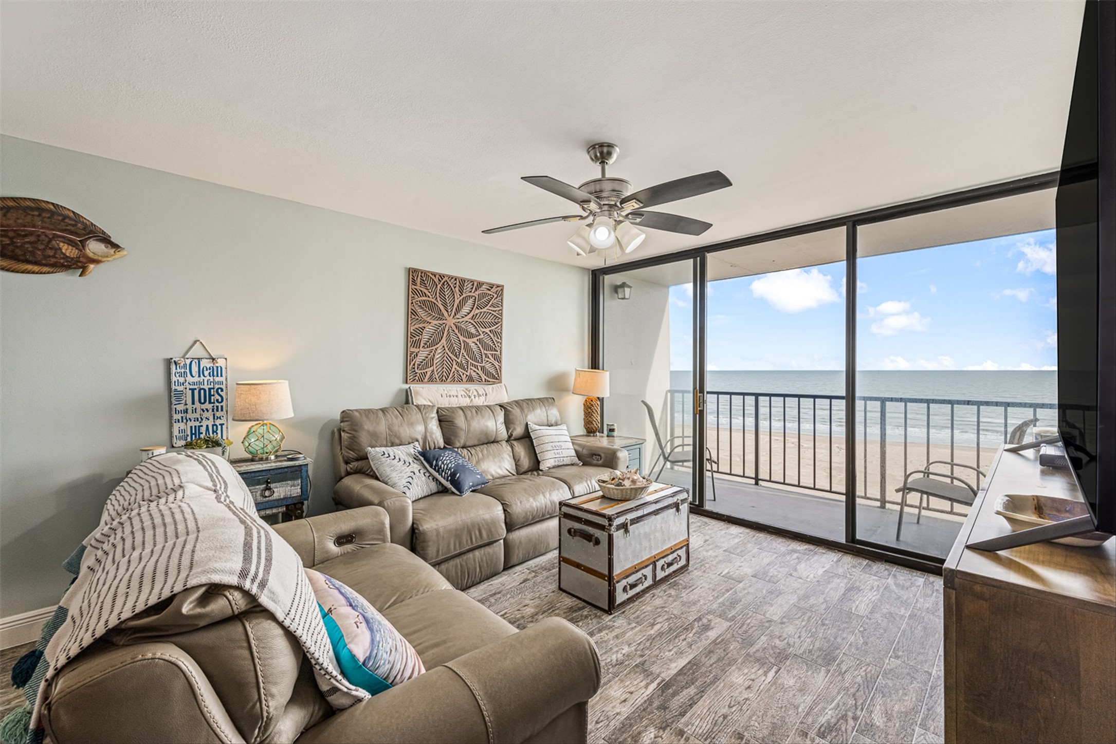 11945 Termini-San Luis Pass Road, Unit 406 Galveston, TX 77554 - Photo 9 of 26 Living area with floor to ceiling windows, wood finished floors, and a ceiling fan