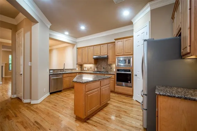 a kitchen with stainless steel appliances granite countertop a refrigerator sink and cabinets