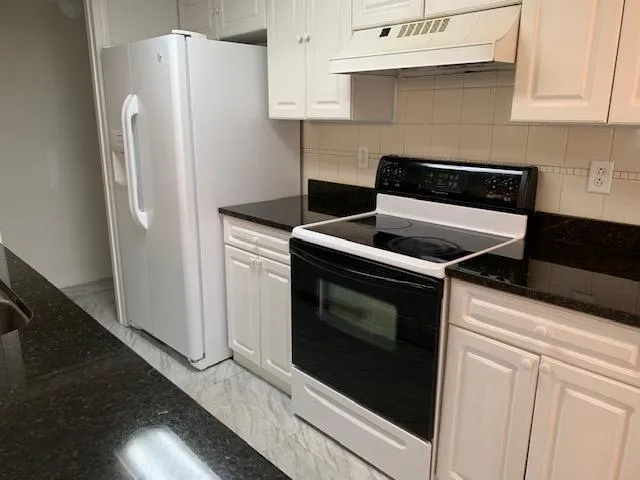 a kitchen with stainless steel appliances wooden cabinets and a stove