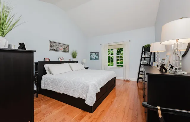 a large bed sitting in a bedroom next to a window with lamp