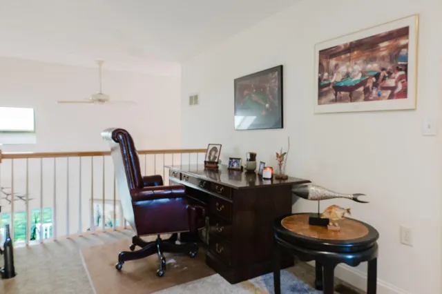 a view of a workspace with furniture and a window