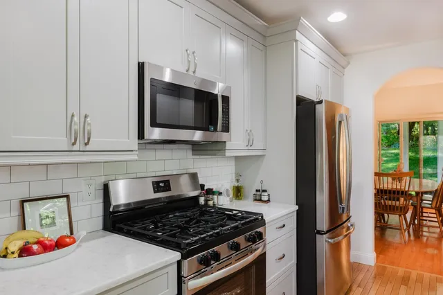 a kitchen with stainless steel appliances granite countertop a stove refrigerator and microwave