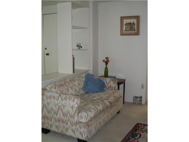 7467 Mission Gorge Road, Unit 83 Santee, CA 92071 - Photo 12 of 24 Television-viewing side of living room with loveseat. Entry door can be seen on other side of divider.