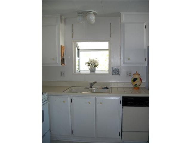 7467 Mission Gorge Road, Unit 83 Santee, CA 92071 - Photo 6 of 24 Greenhouse window over kitchen sink, dishwasher, counter & cabinets