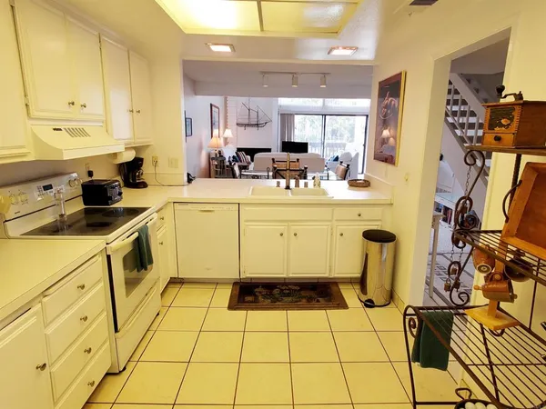 a kitchen with a sink a stove a refrigerator and cabinets