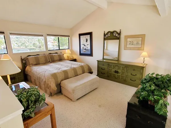 a bedroom with a bed mirror and window