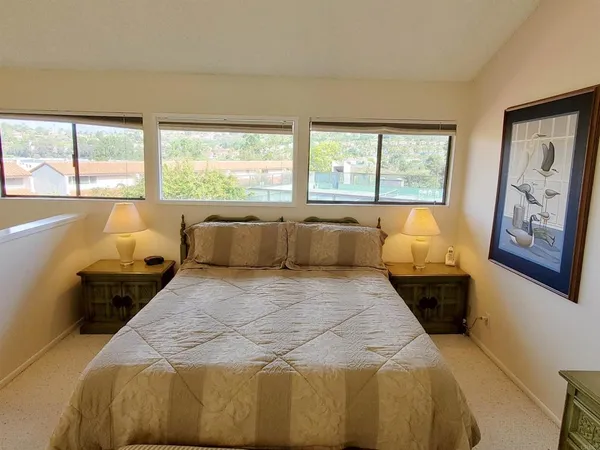 a large bed sitting in a bedroom next to a window