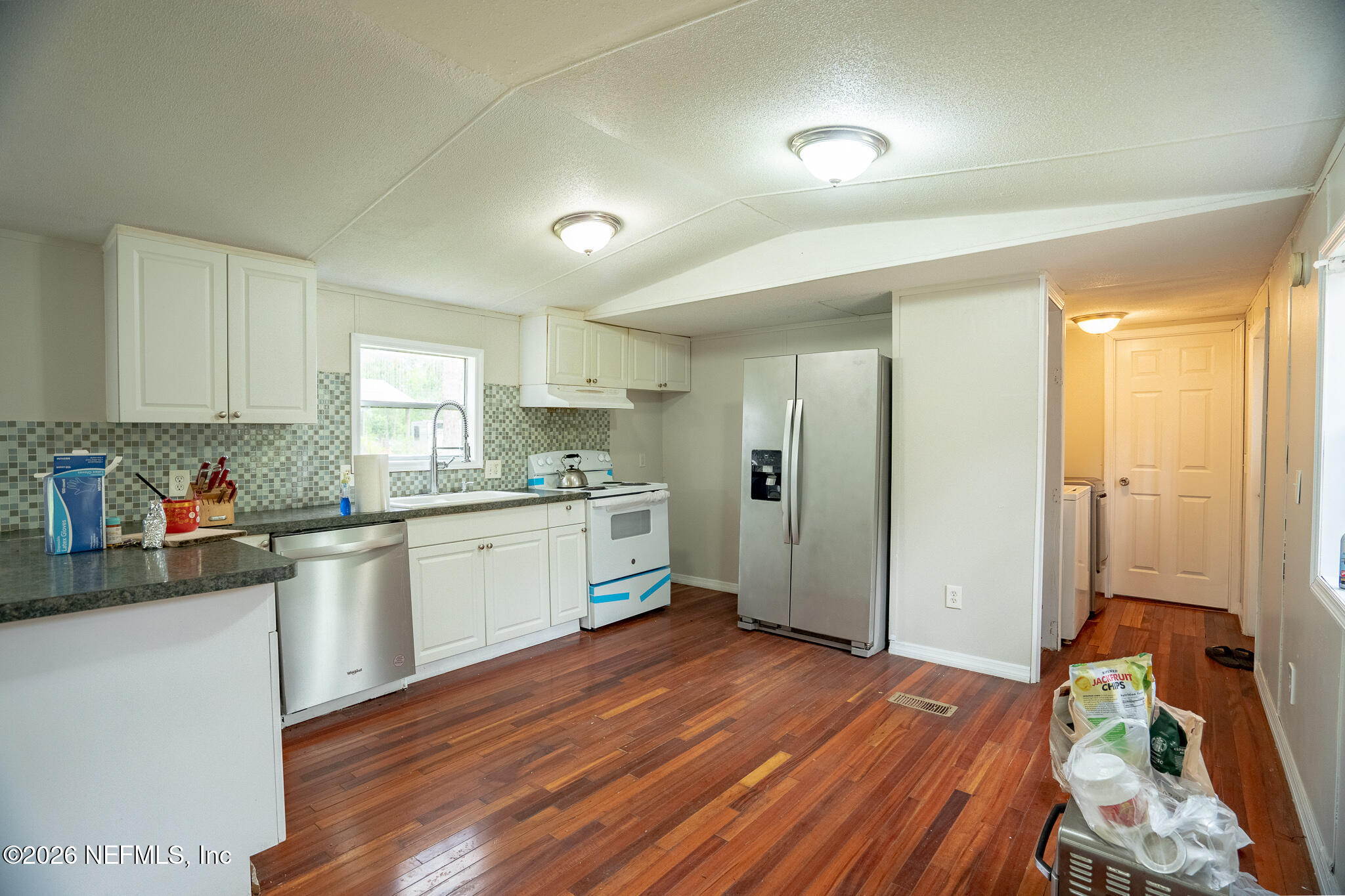 3180 Pacetti Road, Unit A St. Augustine, FL 32092 - Photo 13 of 23 a kitchen with a refrigerator and white cabinets