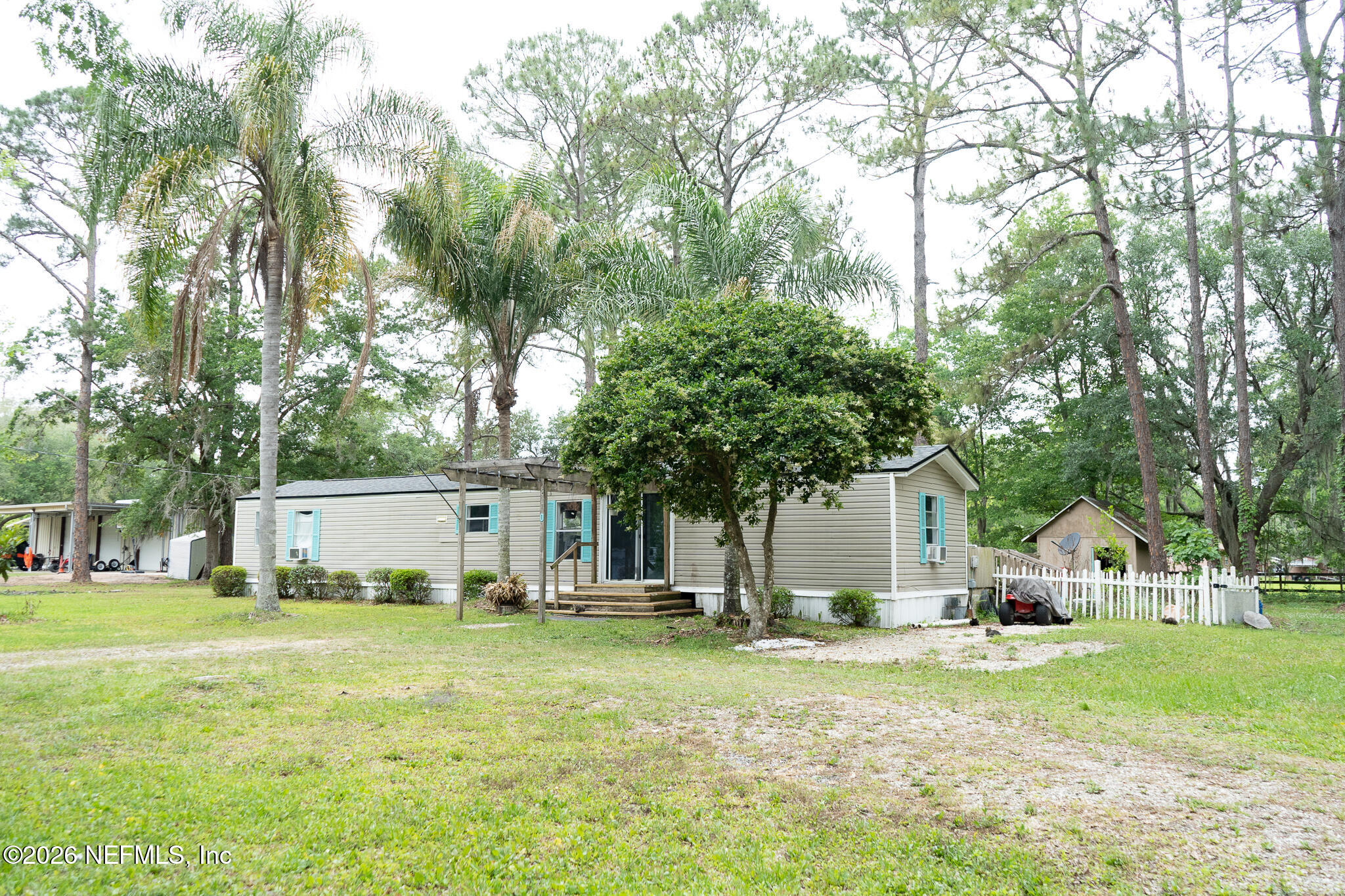 3180 Pacetti Road, Unit A St. Augustine, FL 32092 - Photo 4 of 23 a view of white house with a big yard and large trees