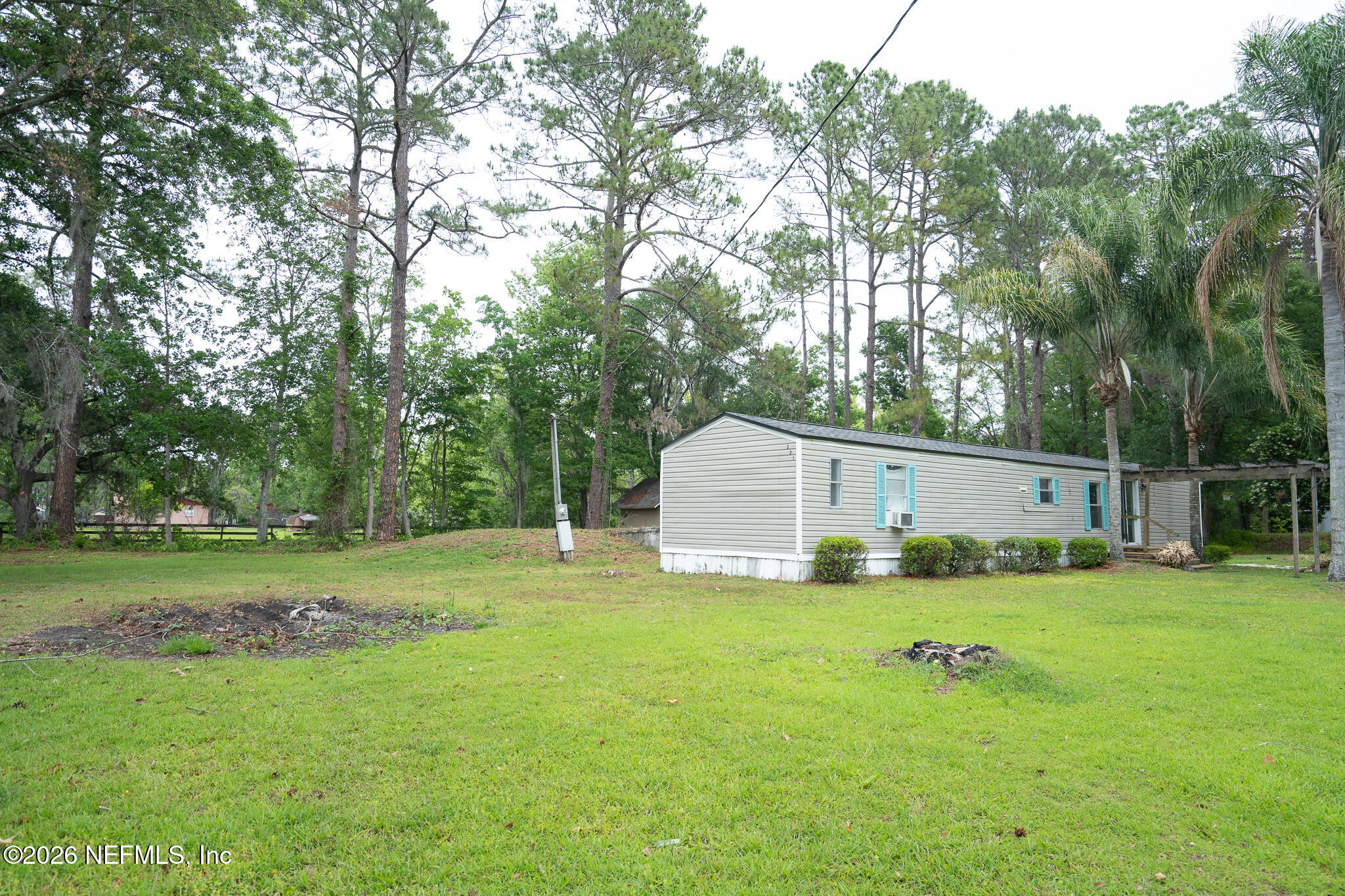 3180 Pacetti Road, Unit A St. Augustine, FL 32092 - Photo 5 of 23 a white house with a big yard and large trees