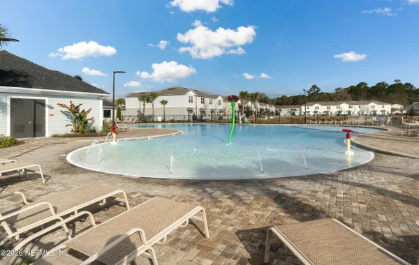 an aerial view of a swimming pool with outdoor seating