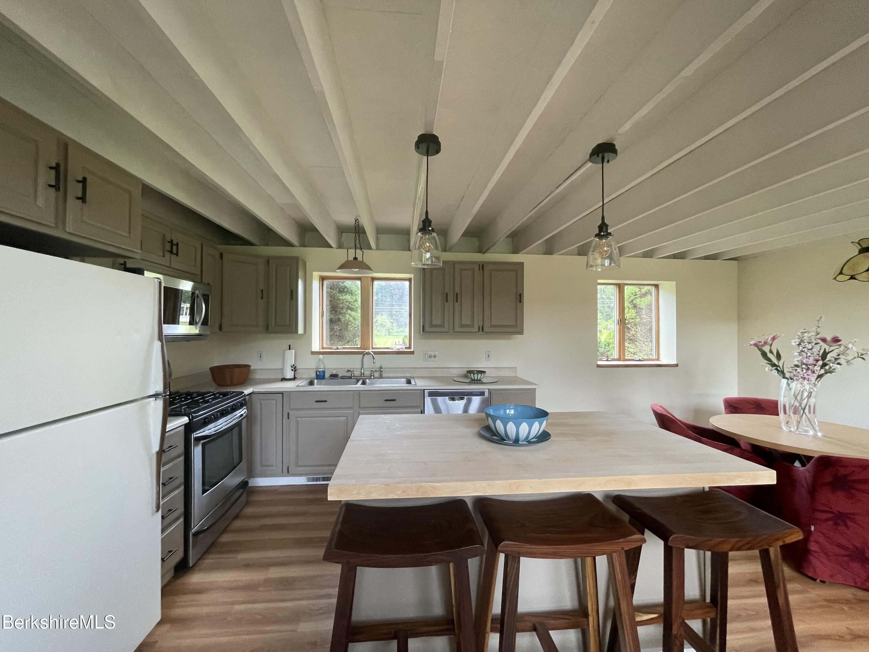 259 Salisbury Road Sheffield, MA 01257 - Photo 27 of 51 a kitchen with granite countertop a dining table chairs and refrigerator