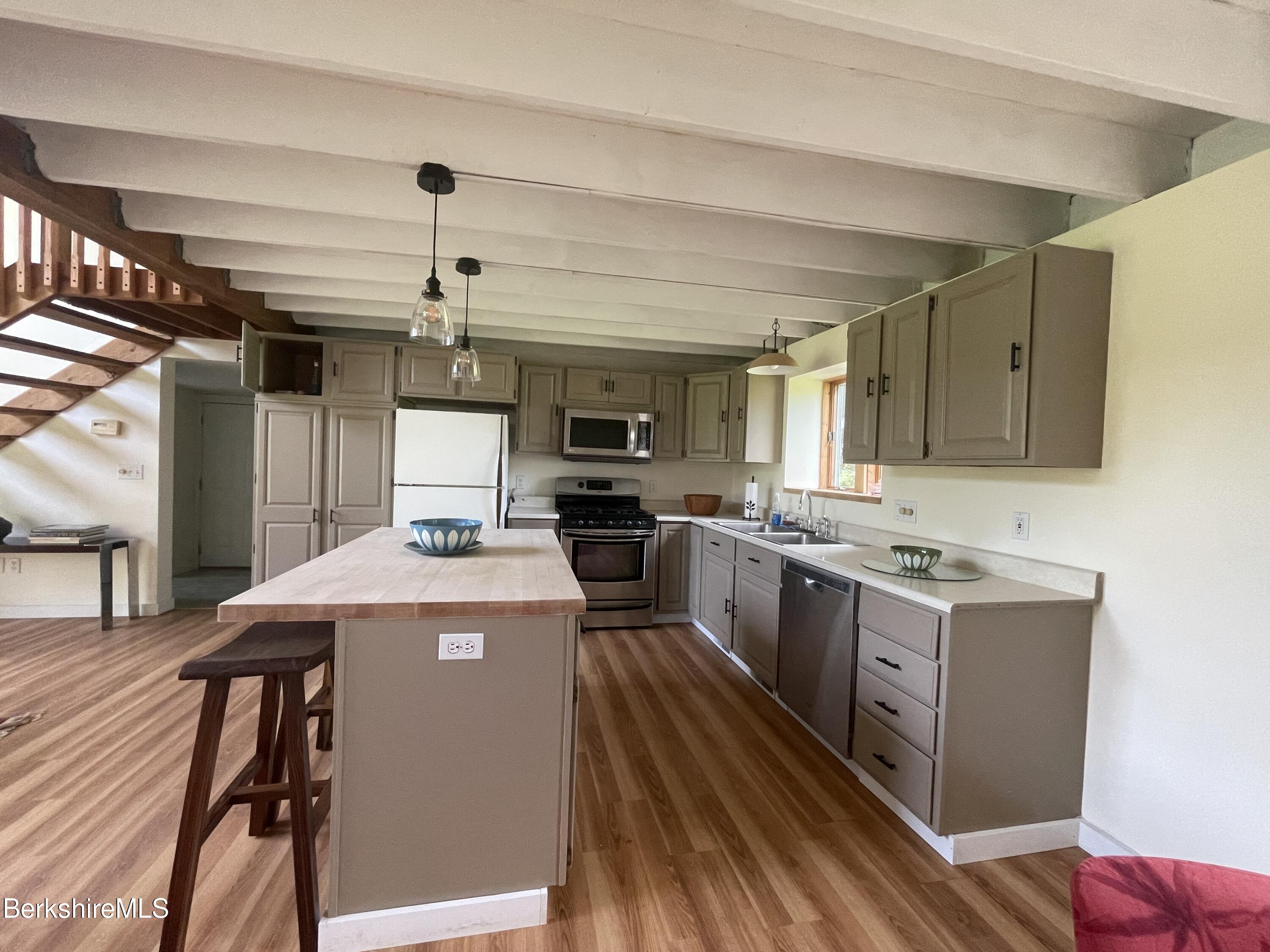 259 Salisbury Road Sheffield, MA 01257 - Photo 29 of 51 a kitchen with kitchen island granite countertop wooden floors and stainless steel appliances