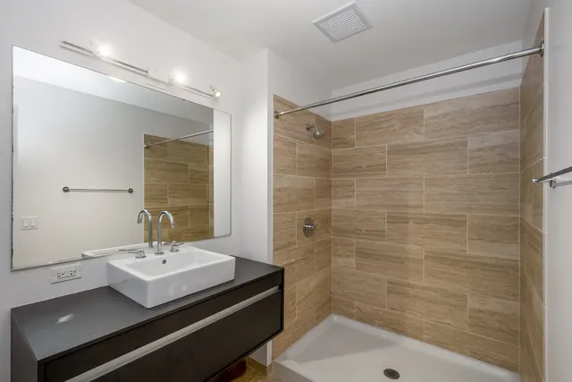 a bathroom with a sink a mirror and a shower