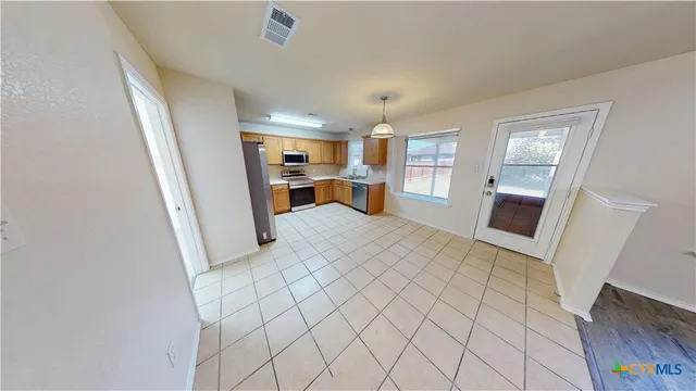 a view of a kitchen with furniture and a refrigerator