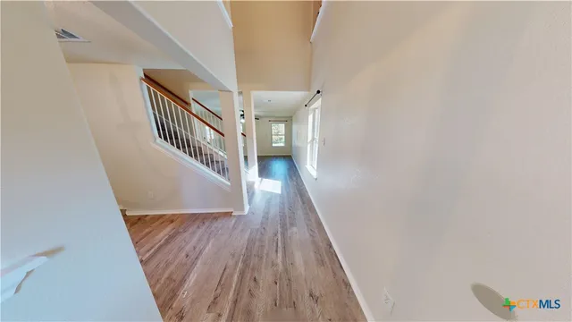a view of a hallway with wooden floor and entryway