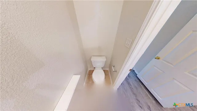 a view of a hallway with toilet and sink