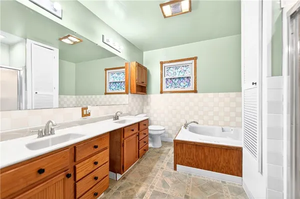 a bathroom with a tub sink and mirror