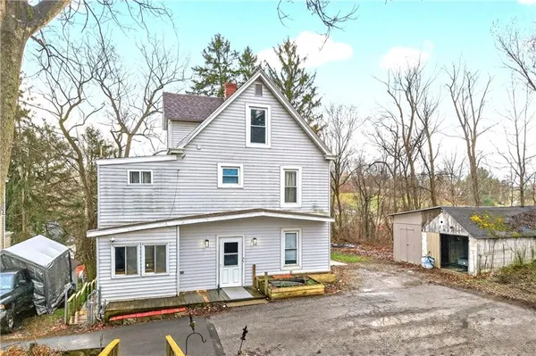 a view of a white house with a large windows and large tree