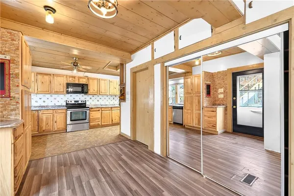 a kitchen with stainless steel appliances kitchen island granite countertop wooden floors and sink