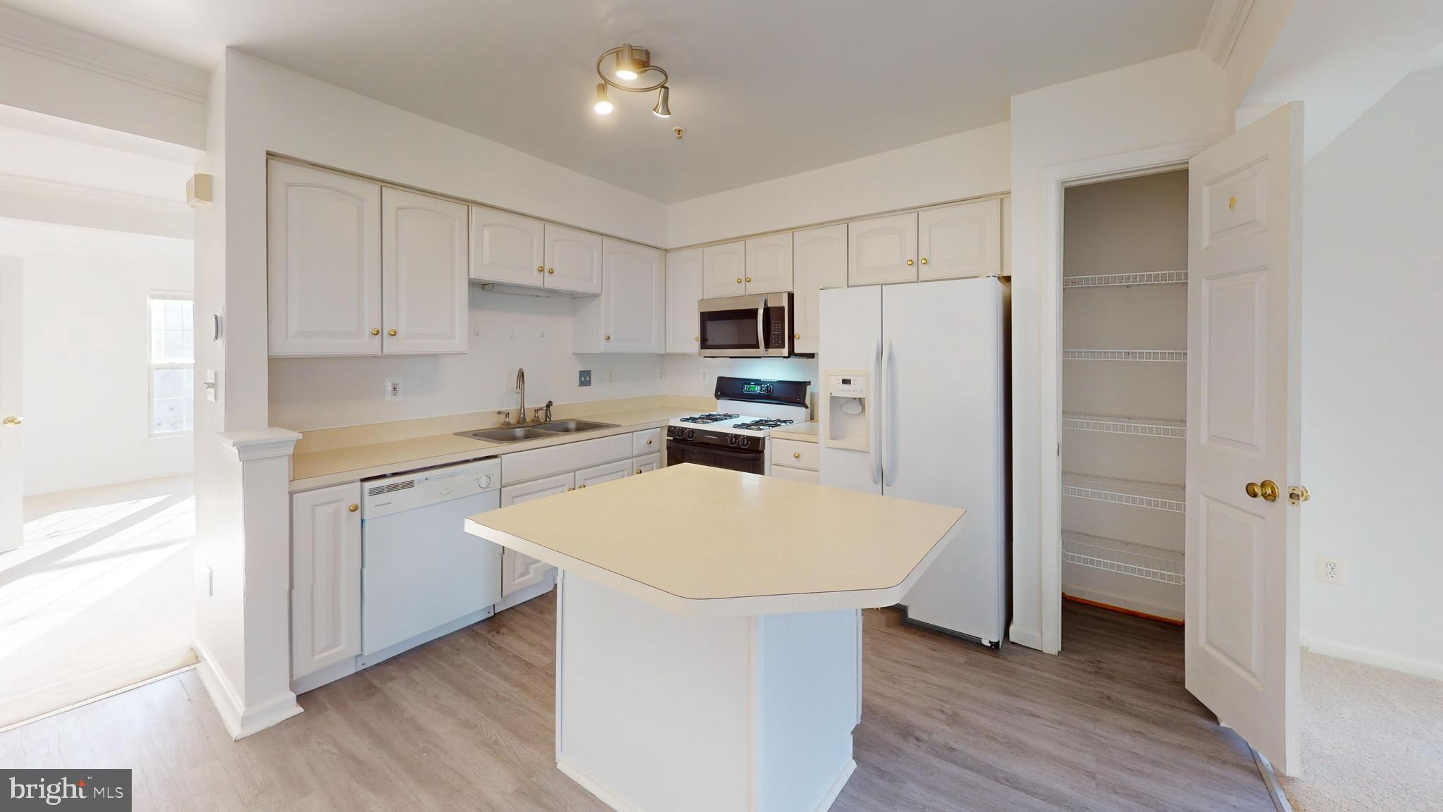 26071 Ridge Manor Drive Damascus, MD 20872 - Photo 4 of 29 a kitchen with white cabinets and stainless steel appliances