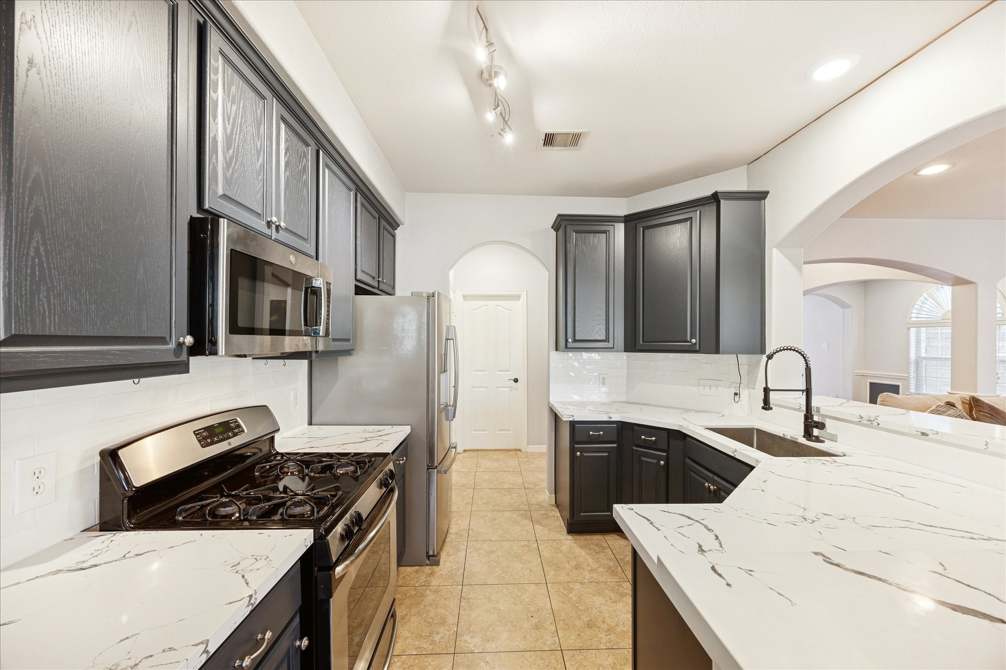 6426 East Linpar Court Houston, TX 77040 - Photo 10 of 23 a kitchen with stainless steel appliances a sink stove and cabinets