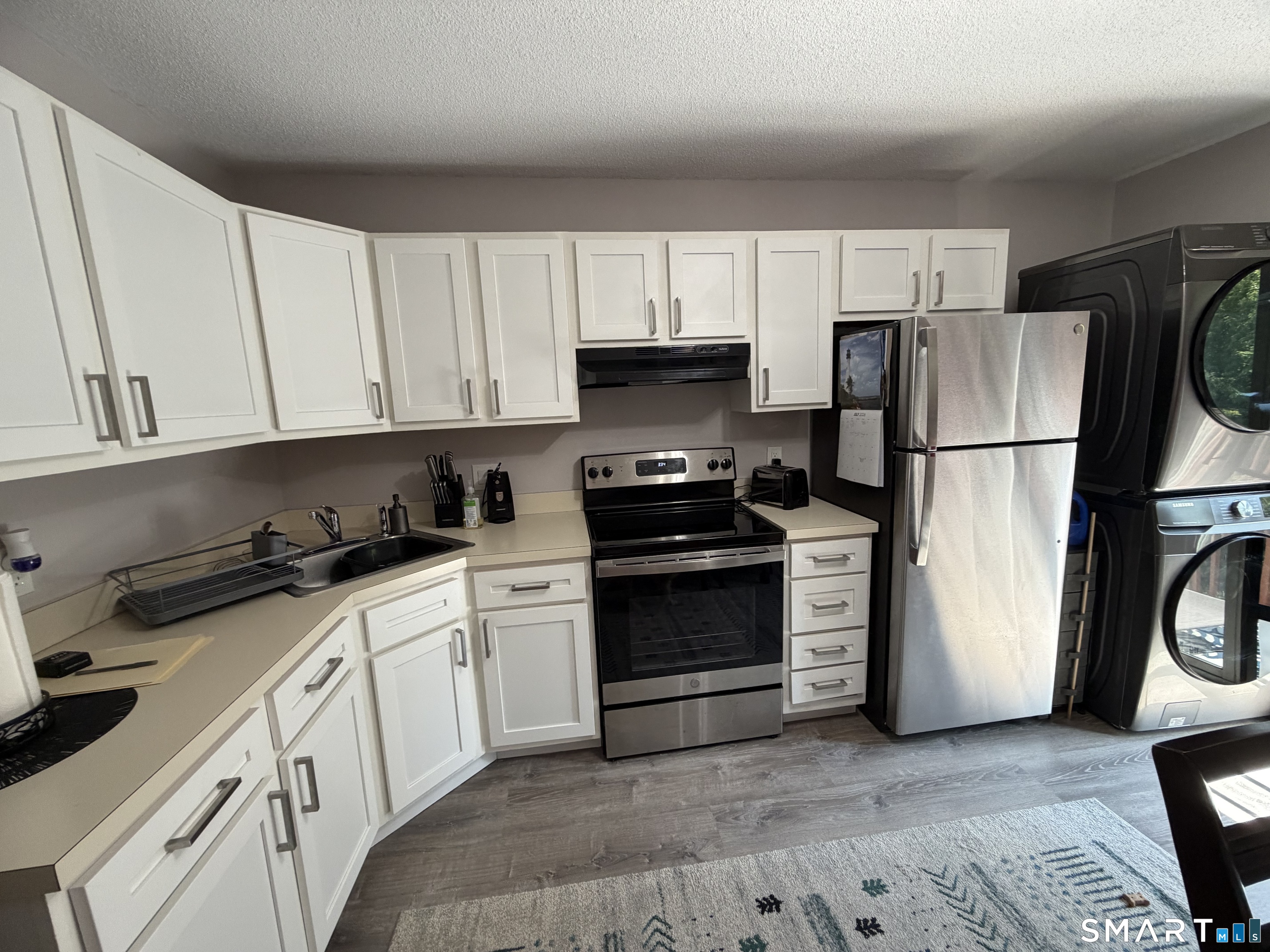 21 Lisa Court, Unit 10 Waterbury, CT 06704 - Photo 2 of 14 a kitchen with a refrigerator and a stove top oven