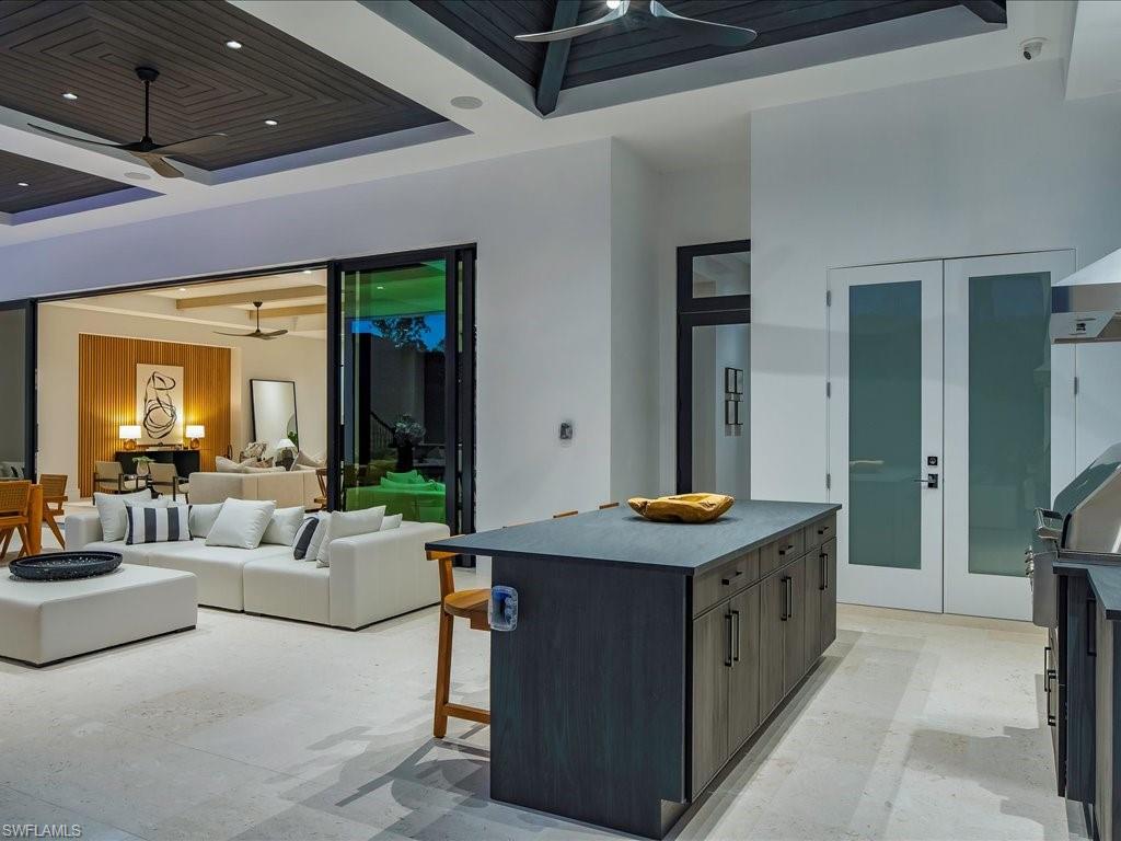612 Binnacle Drive Naples, FL 34103 - Photo 22 of 50 Kitchen featuring a kitchen breakfast bar, recessed lighting, a raised ceiling, a kitchen island, and a ceiling fan