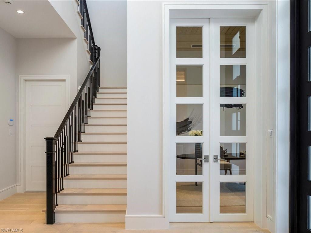 612 Binnacle Drive Naples, FL 34103 - Photo 33 of 50 Staircase featuring french doors, recessed lighting, baseboards, and wood finished floors