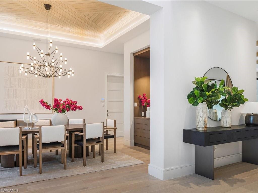 612 Binnacle Drive Naples, FL 34103 - Photo 10 of 50 Dining space with wooden ceiling, a raised ceiling, wood finished floors, baseboards, and an inviting chandelier
