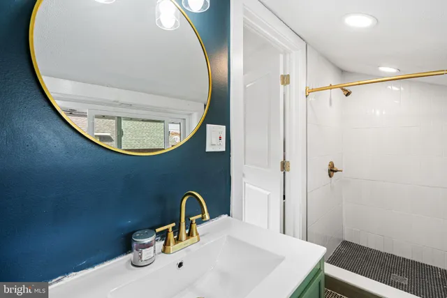 a bathroom with a sink a mirror a toilet and shower