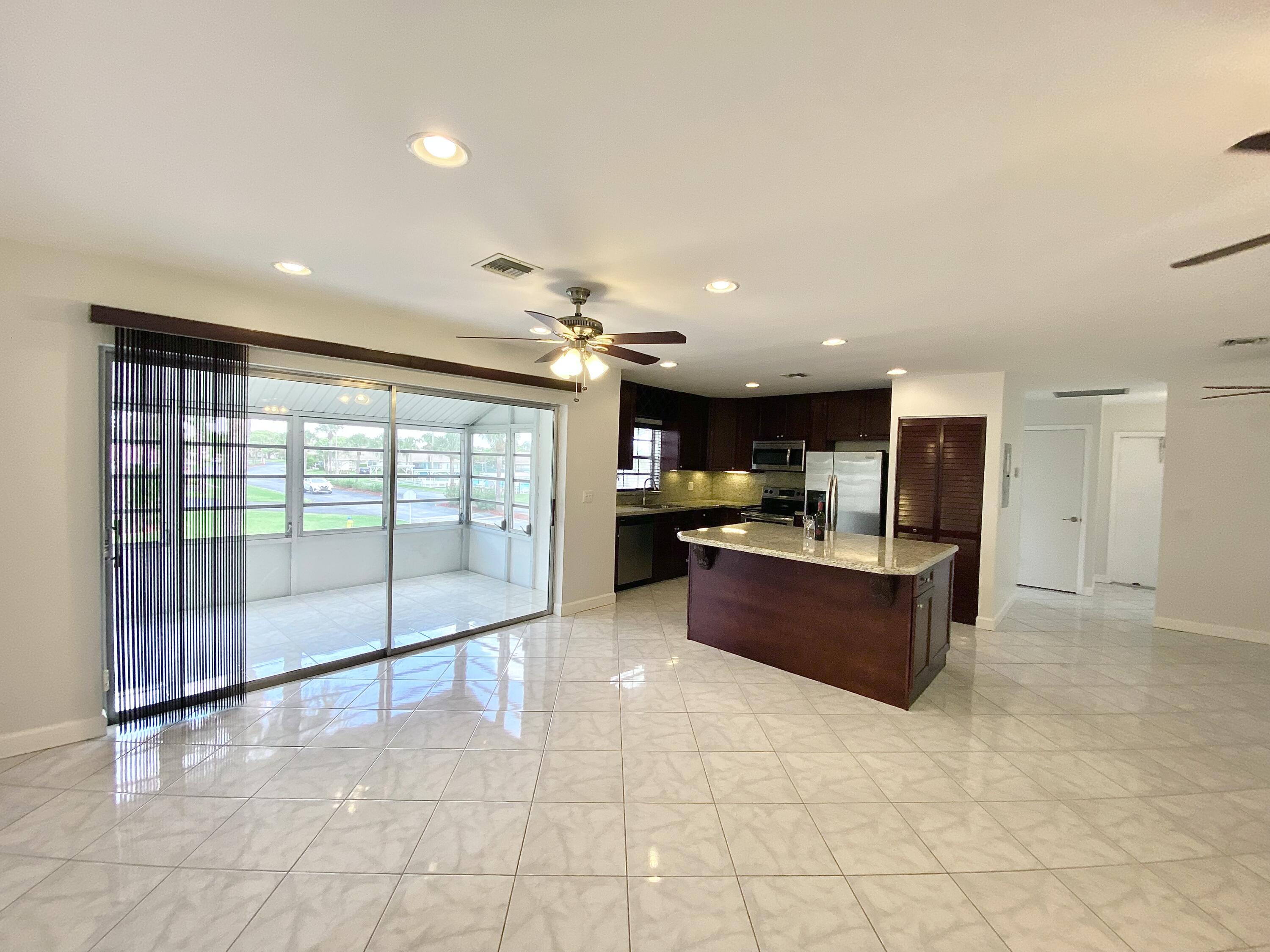 a large kitchen with stainless steel appliances kitchen island granite countertop a refrigerator and a sink
