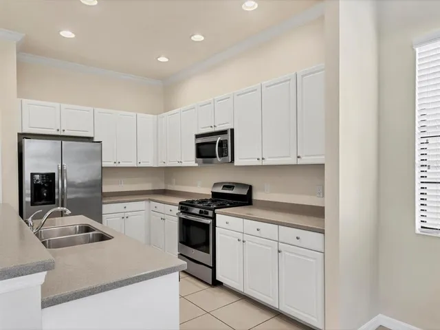 a kitchen with cabinets stainless steel appliances and sink