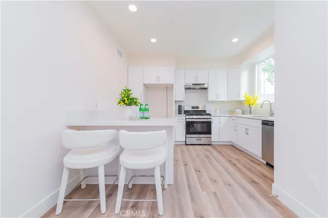 a kitchen with a table chairs and white cabinets